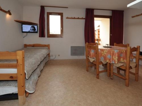 une chambre avec un lit, une table et des chaises dans l'établissement Studio cabine 4 pers Les Menuires - Balcon sud, ski aux pieds, proche commerces et ESF - FR-1-178-41, aux Menuires