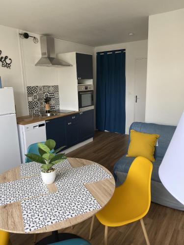 une cuisine et un salon avec une table et des chaises dans l'établissement Super appartement cosy, parking privé, à Courseulles-sur-Mer