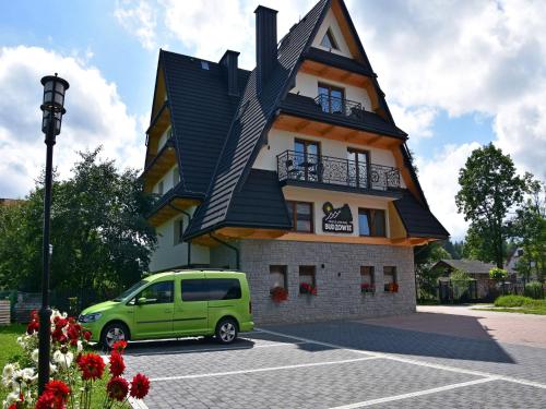 a green van parked in front of a building at Pokoje Gościnne Budzowie in Czarna Góra