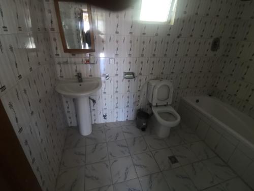 a bathroom with a sink and a toilet and a tub at Lalibela Hotel in Lalībela