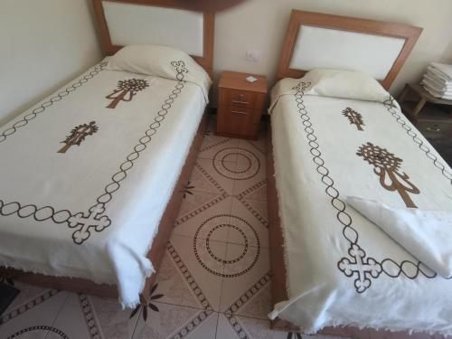 - deux lits assis l'un à côté de l'autre dans une pièce dans l'établissement Lalibela Hotel, à Lalibela