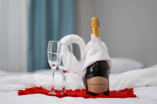 a bottle of wine next to two wine glasses at Hotel Puerto San Luis in Tilarán
