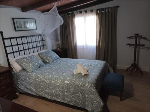 a bedroom with a bed with a blue comforter at Casa Rural La ilusion in Málaga