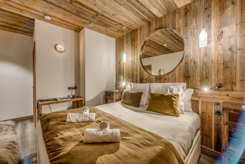 a bedroom with a large bed with two towels on it at Hotel & Spa Le Val d'Isère in Val dʼIsère