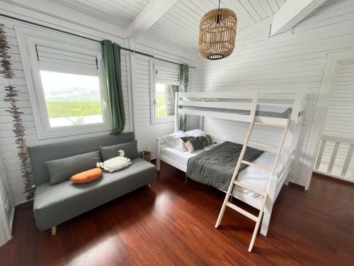 a bedroom with a bunk bed and a ladder at Superbe Villa Bwa Lélé in Rivière-Salée