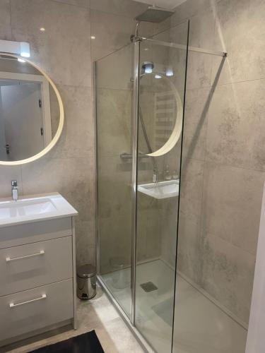 Apartament Sea & Lake z basenem Silence Mielno في ميلنو: حمام مع دش زجاجي ومغسلة