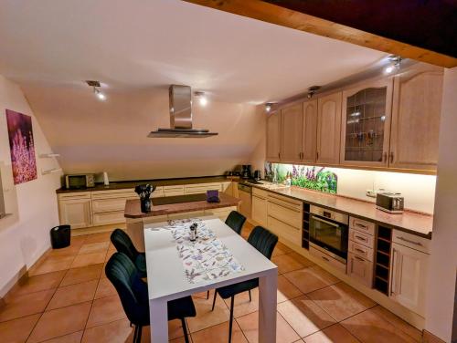 a kitchen with a white table and some chairs at Große Schönheit mit Panoramablick in Euskirchen