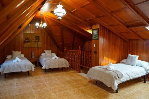 two beds in a room with wooden walls and ceilings at TESS Villa Cari in Alhaurín de la Torre