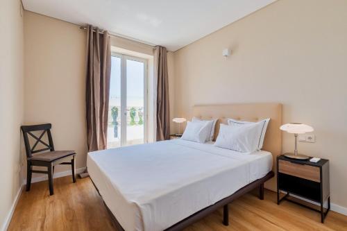una camera da letto con un grande letto bianco e una finestra di Setubal Prime Penthouse a Setúbal