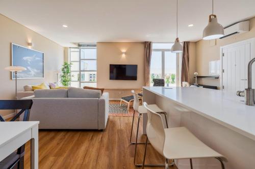 a kitchen and living room with a couch and a table at Setubal Prime Penthouse in Setúbal