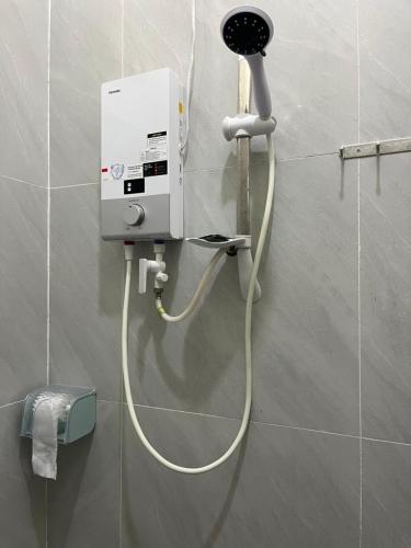 a hair dryer on a wall in a bathroom at NHÀ NGHỈ HOÀNG GIA - TT Lai Vung in Lai Vung