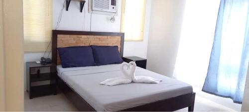 un conejo blanco sentado en una cama en una habitación en BBJE Property, en Dauis