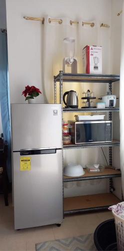 a kitchen with a white refrigerator and a microwave at BBJE Property in Dauis