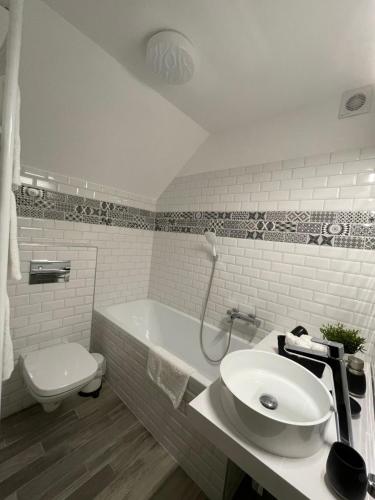 bagno bianco con lavandino e servizi igienici di City Nest Eger a Eger