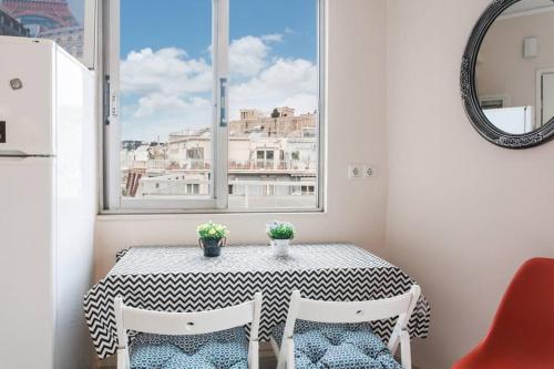 mesa pequeña con 2 sillas y ventana en Lovely APT w/heated Jacuzzi &full Acropolis view en Atenas