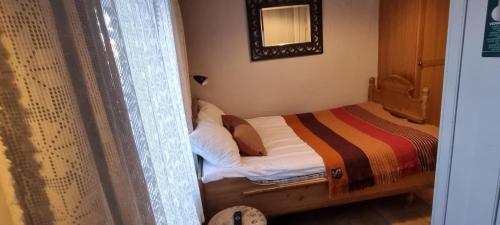 a small bed in a room with a window at Erzscheidergaarden Hotell in Røros