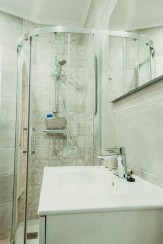 a bathroom with a shower and a white sink at Apartamento turístico Cedeira Casa Bustabad in Cedeira