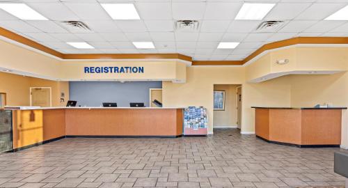 a large lobby with a reception desk and a sign that reads registration at Developer Inn Downtown Orlando in Orlando