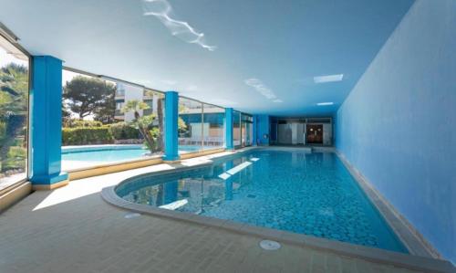 une piscine dans un immeuble avec une grande fenêtre dans l'établissement Residence Eden park, à Cannes