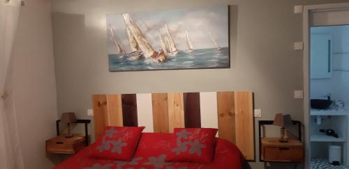 un salon avec un canapé rouge et un tableau mural dans l'établissement Hébergement Chambre d'hôtes Grau du Roi Mas des Marines Piscine Adult only, au Grau-du-Roi