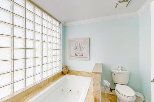 a bathroom with a tub and a toilet at Sterling Sands 614 in Destin
