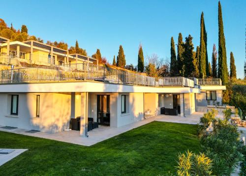 een grote villa met een gazon en bomen bij Sunset Lodge in Garda