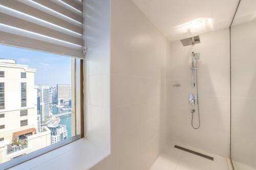a bathroom with a shower and a window at Ultra Luxury JBR Duplex Penthouse - Beach Resorts Neighbourhood in Dubai