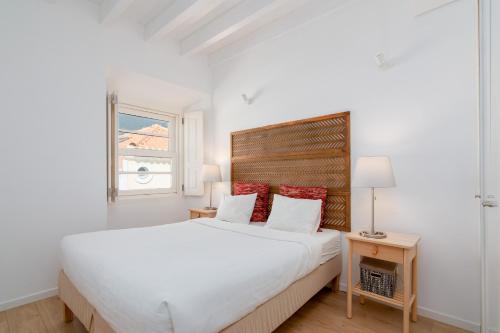 a white bedroom with a large bed and a window at Setubal Downtown Bocage I e II in Setúbal
