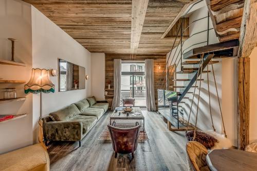 a living room with a couch and a staircase at Hotel & Spa Le Val d'Isère in Val dʼIsère