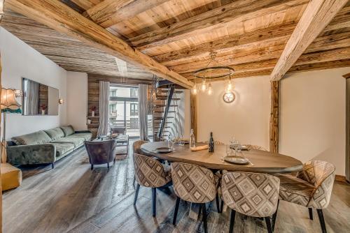 a dining room with a table and chairs and a couch at Hotel & Spa Le Val d'Isère in Val dʼIsère