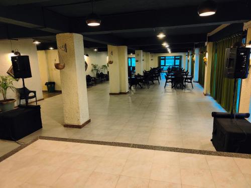una grande stanza con tavoli e sedie in un edificio di Hotel Acropolis a Shillong
