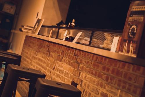 a bar with a brick wall and some bar stools at Waiting Homestay in Taitung City