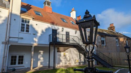 a street light in front of a building with a staircase at Slateford House 1770 Luxury Aparthotel by The House of Danu in Edinburgh