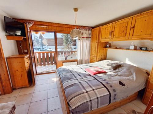 um quarto com uma cama e uma varanda em Appartement Samoëns, 3 pièces, 4 personnes - FR-1-624-73 em Samoëns