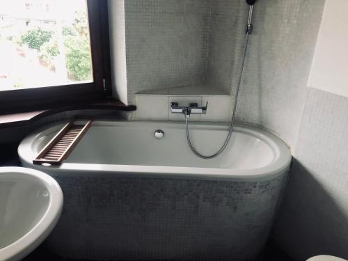 a bathroom with a bath tub and a sink at Mansarda a pochi km da Milano in Gessate