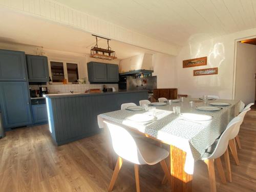 une salle à manger avec une table et des chaises et une cuisine dans l'établissement Duplex rénové pour 14 pers, avec balcon et parking - FR-1-624-92, à Samoëns