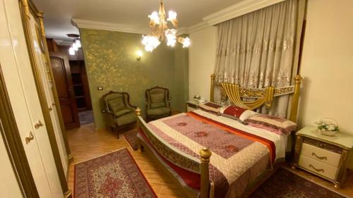 1 dormitorio con 1 cama, 2 sillas y lámpara de araña en مدينه 6 اكتوبر حدائق الفردوس الامن العام فيلا ٢٤٧ شارع ٨ en Madīnat Sittah Uktūbar