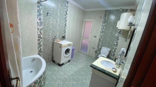 uma casa de banho com um lavatório e uma máquina de lavar roupa em مدينه 6 اكتوبر حدائق الفردوس الامن العام فيلا ٢٤٧ شارع ٨ em Madīnat Sittah Uktūbar