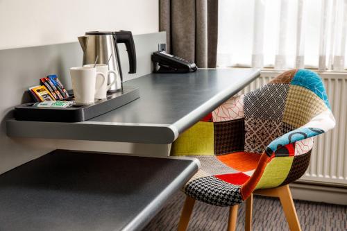 a chair sitting at a counter with a table at Mercure Chester Abbots Well Hotel in Chester