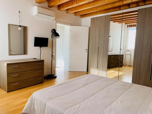 een slaapkamer met een bed, een dressoir en een spiegel bij Appartamento Donà in Rovigo