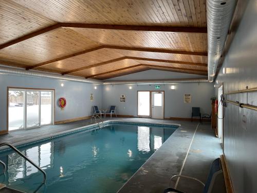 uma grande piscina interior com tecto em madeira em Ambassador Motel em Sault Ste. Marie