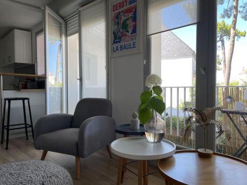 a living room with a chair and a table at Studio de charme sous les pins au calme in La Baule