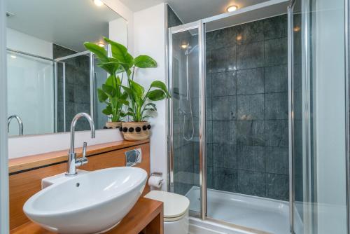 a bathroom with a sink and a shower at 2 bedroom apartment with park views Shoreditch in London