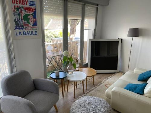 un salon avec un canapé et une télévision dans l'établissement Studio de charme sous les pins au calme, à La Baule