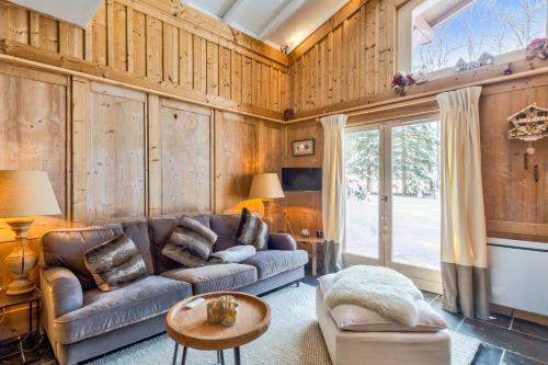a living room with a couch and a table at Beautiful suite with garden at the foot of the slopes - Welkeys in Megève