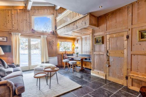 a living room with wooden walls and a table and chairs at Beautiful suite with garden at the foot of the slopes - Welkeys in Megève