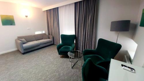 uma sala de estar com um sofá e cadeiras num quarto de hotel em Stara Biblioteka em Breslávia