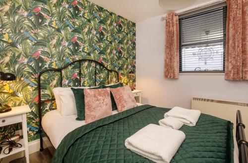 a bedroom with a green bed with a floral wallpaper at The Holgate Hideaway with Hot Tub in York