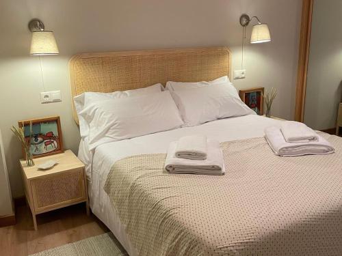 una camera da letto con un letto e due asciugamani di Housingcoruña ORILLAMAR a La Coruña
