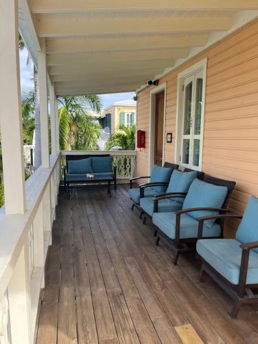 a porch with blue chairs on a house at The Fred - Adults only Hotel in Frederiksted
